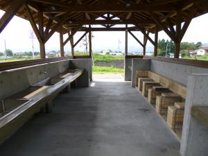 左側に流し場3口、右側に釜場6基と作業台がある炊事棟内を写した写真