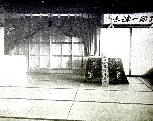 和室の向かって右側の壁上部に「終始一誠意」と書かれた扁額が飾られている白黒写真
