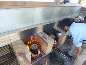 食材を入れた縄文土器を火にかけ調理をしている写真