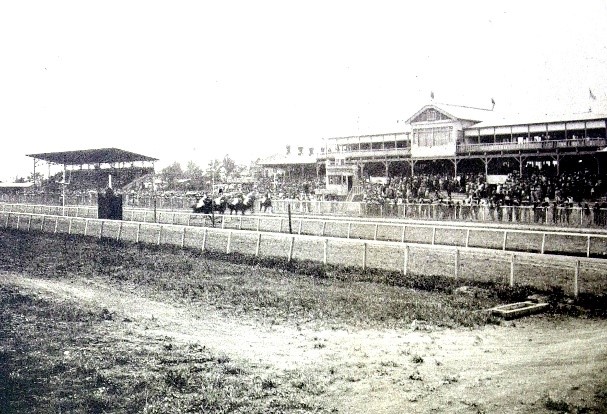 大勢の人たちが競馬を観戦している白黒写真