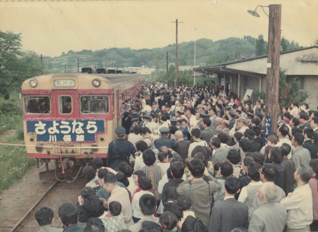 「さようなら川俣線」と書かれたボードが貼られた列車が停まっているホームが、多くの人で埋め尽くされている写真