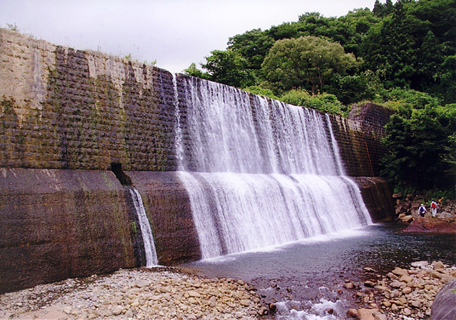 コンクリート製の荒川第五堰堤からしぶきをあげて水が流れ落ちている写真