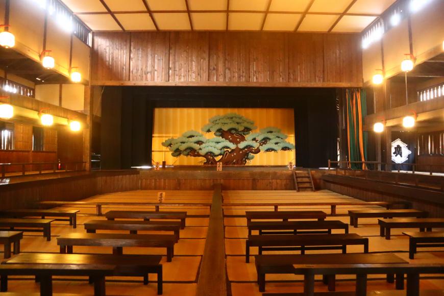 大きな松が描かれた松羽目がステージ背景にある広瀬座内観の写真