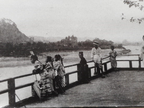 着物を着た子どもたちが観望台から川を覗いている様子の白黒写真