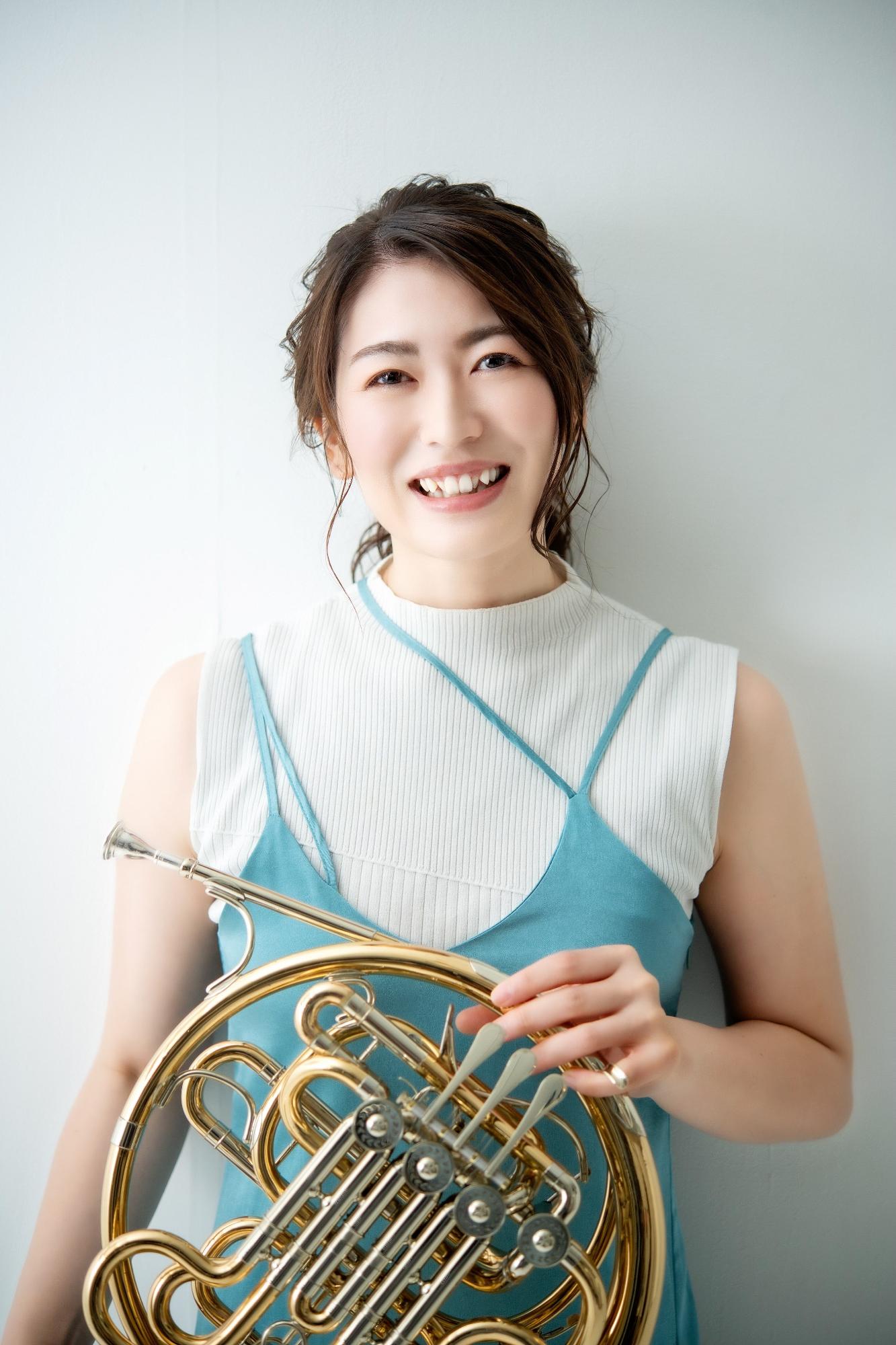 ホルンを手に持つ佐藤さんの写真