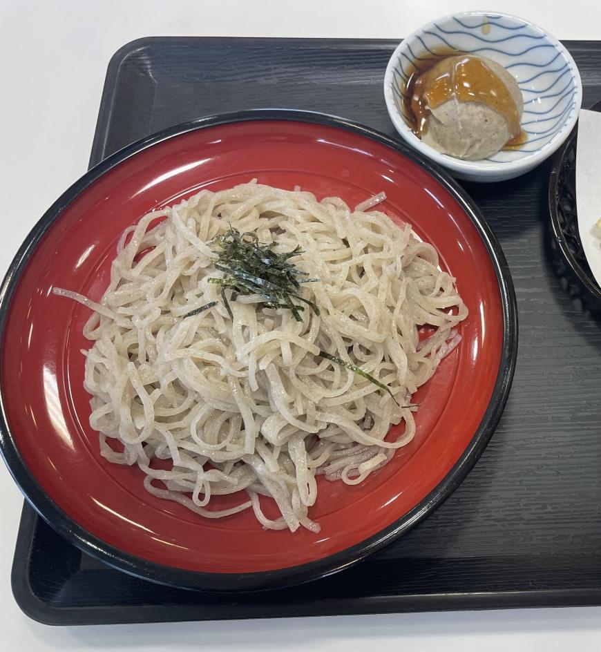 赤い器に盛られ刻みのりがトッピングされた「新そば」の写真