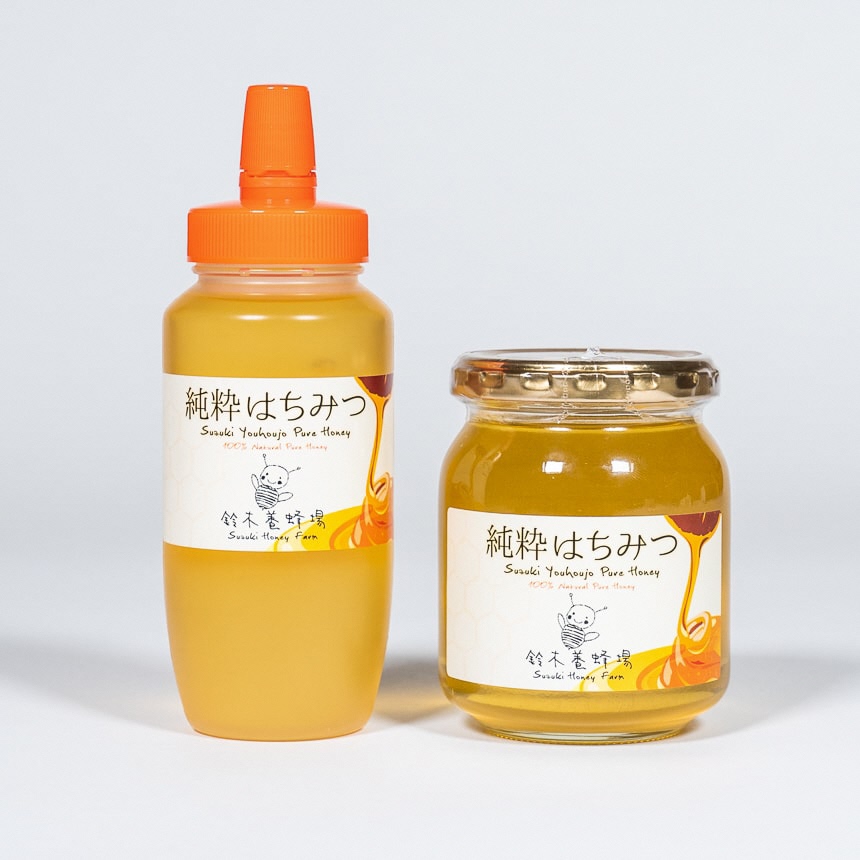 プラスチックのボトルに入ったはちみつと、ガラスの瓶に入ったはちみつが並べて置かれている写真