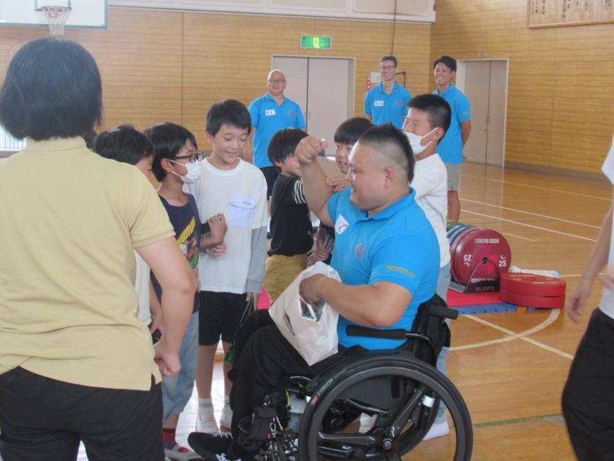 車いすに座った渡邉和幸選手の周りに生徒達が集まっている写真