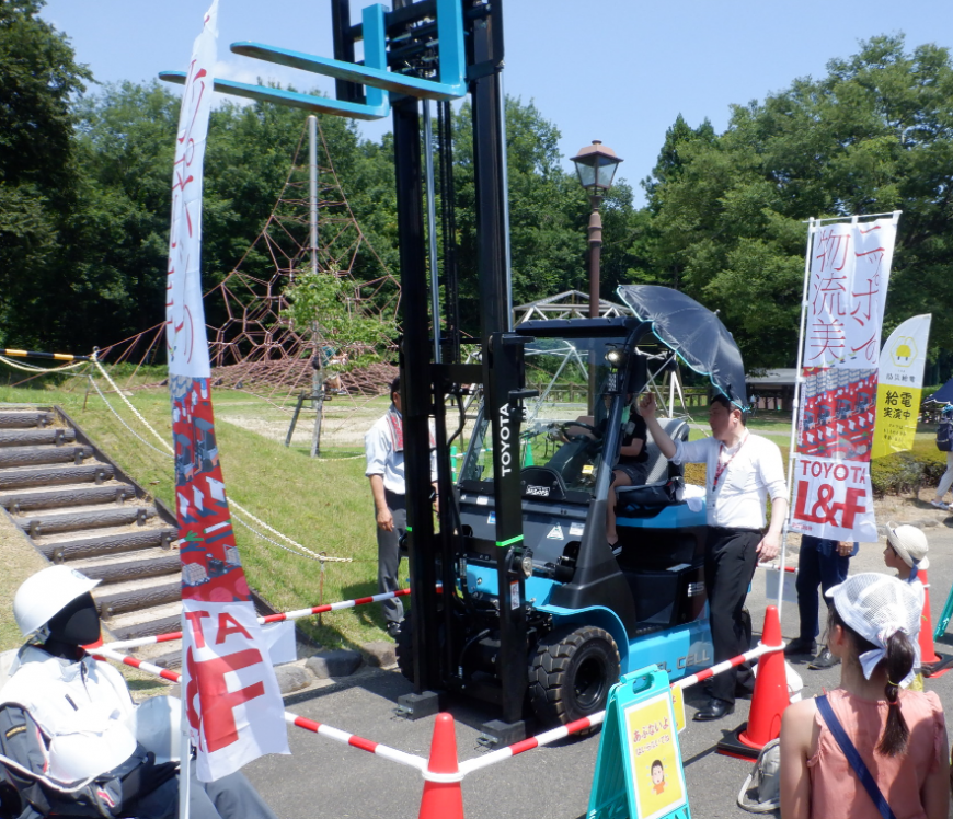 展示されているフォークリフトを見学している来場者の写真