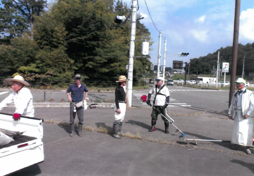 横断歩道側の歩道に参加者が機械などを手に持ち集まっている写真
