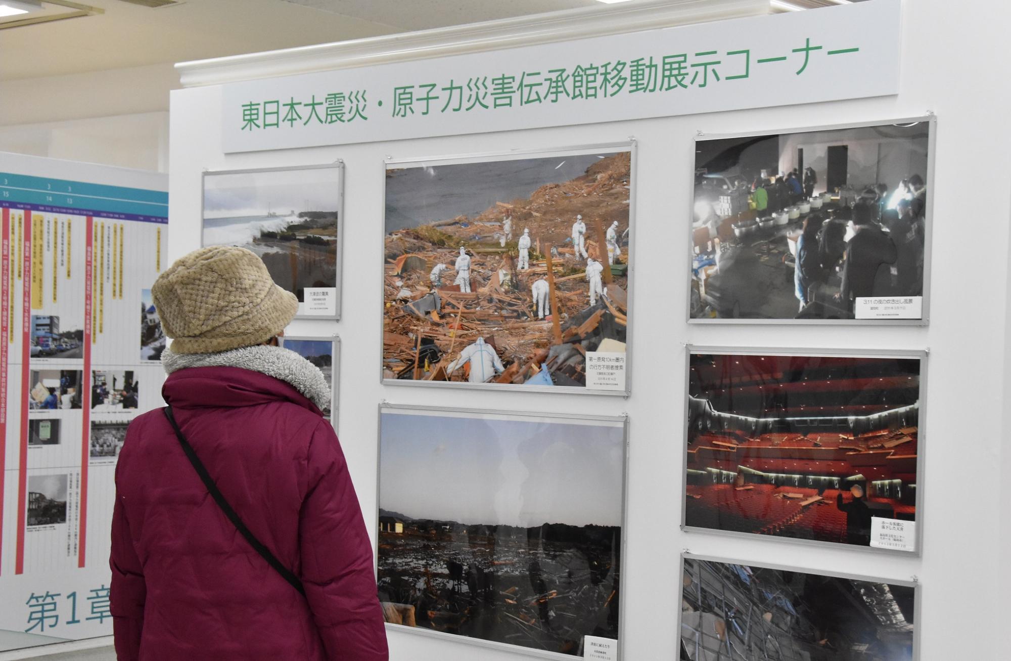 東日本震災・原子力災害伝承館移動展示コーナーの作品を一人の女性が見ている様子を写した写真