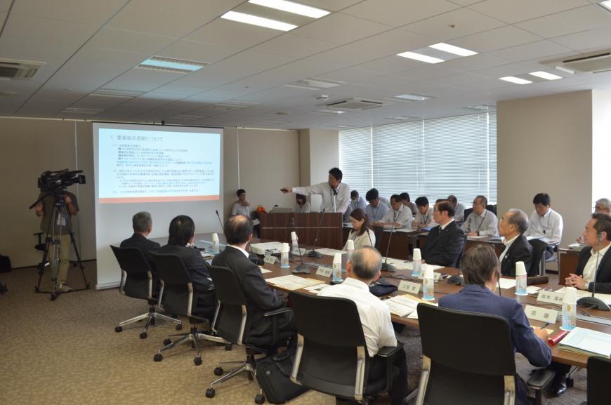 資料が投影されたスクリーンの横の演壇で話をしている男性と着席して話を聞いている参加者の写真