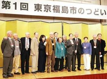 第1回東京福島市のつどいの舞台で男女が記念撮影をしている写真
