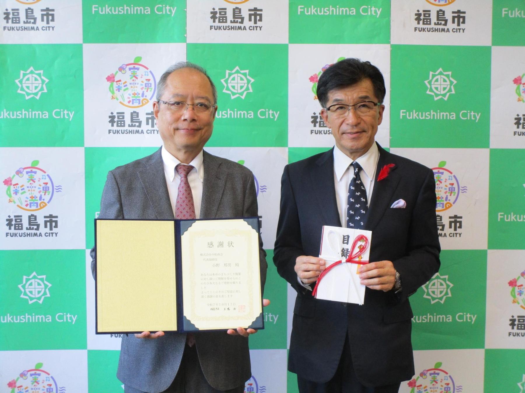 企業版ふるさと納税の寄附贈呈式です。左に株式会社中松商会の薮内取締役、右に福島市長が立っています。