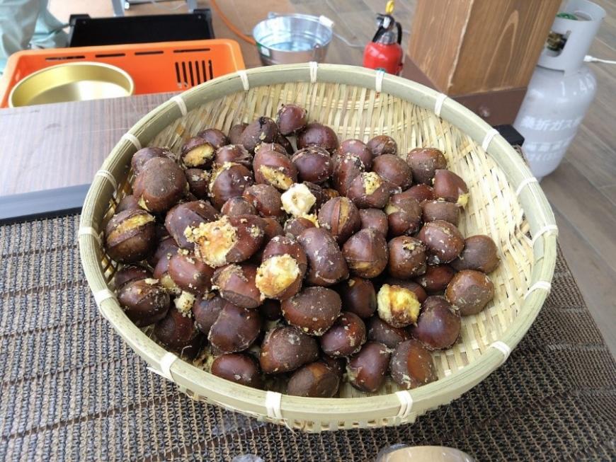 竹かごにたくさん入った焼き栗の写真