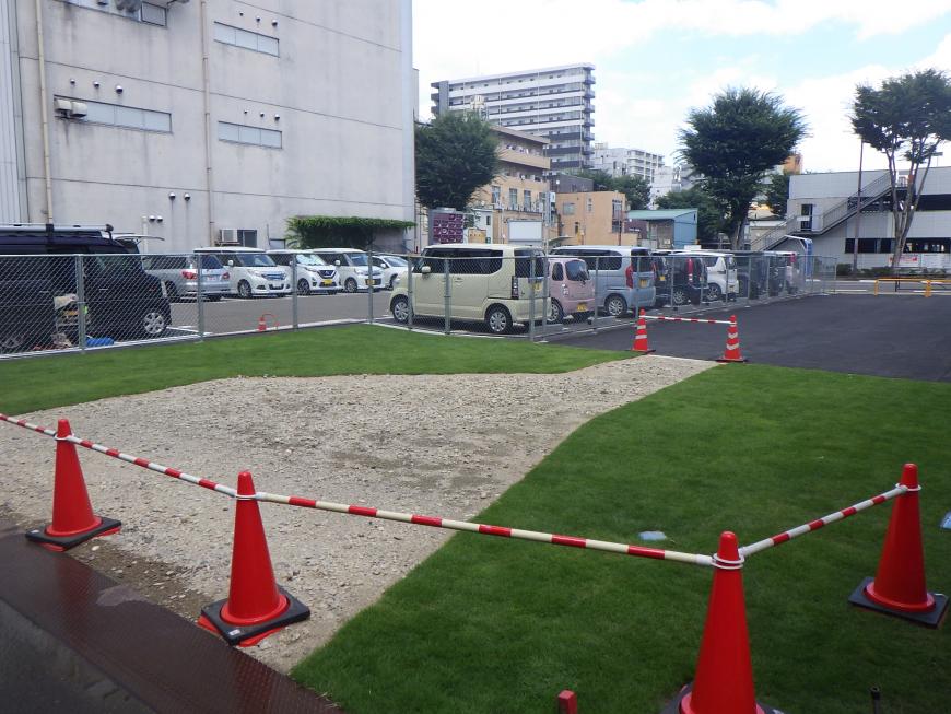 施行予定の砂利と芝生になっている土地をカラーコーンなどで仕切りがされている施工前の写真