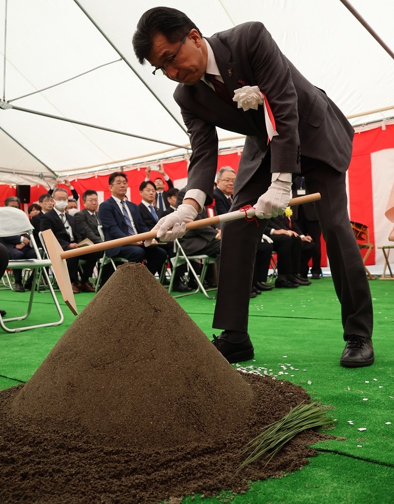 祈願祭で市長が盛砂に鍬を入れている写真