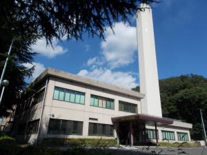 右側に白い煙突のようなものがある2階建ての事務所外観を写した写真
