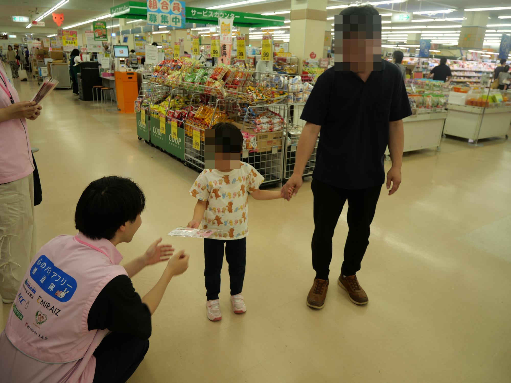親子に啓発グッズを渡している様子