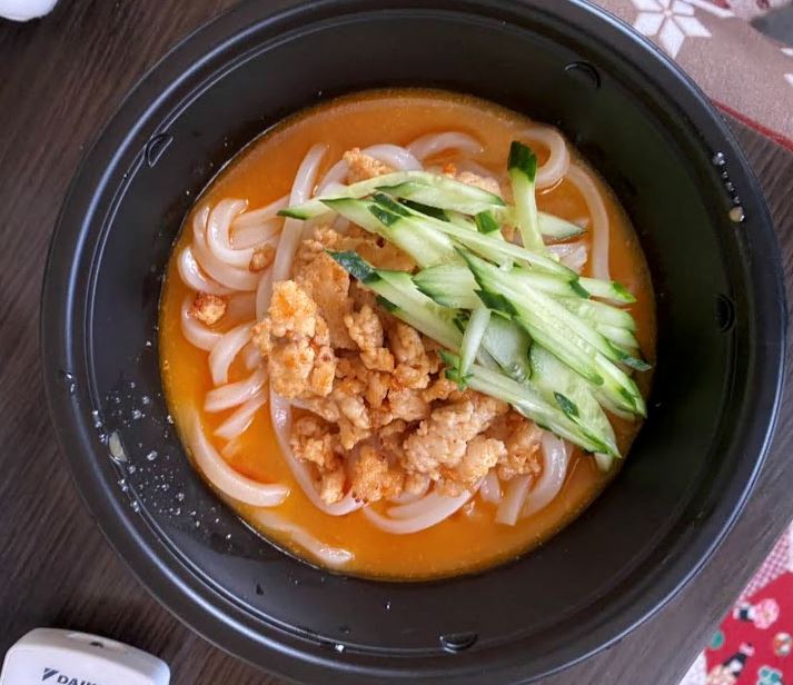 うどんの上にひき肉やキュウリが添えられた冷やし担々うどんの写真