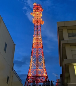福島電力センター無線鉄塔がオレンジ色にライトアップされている様子を下から撮影した写真