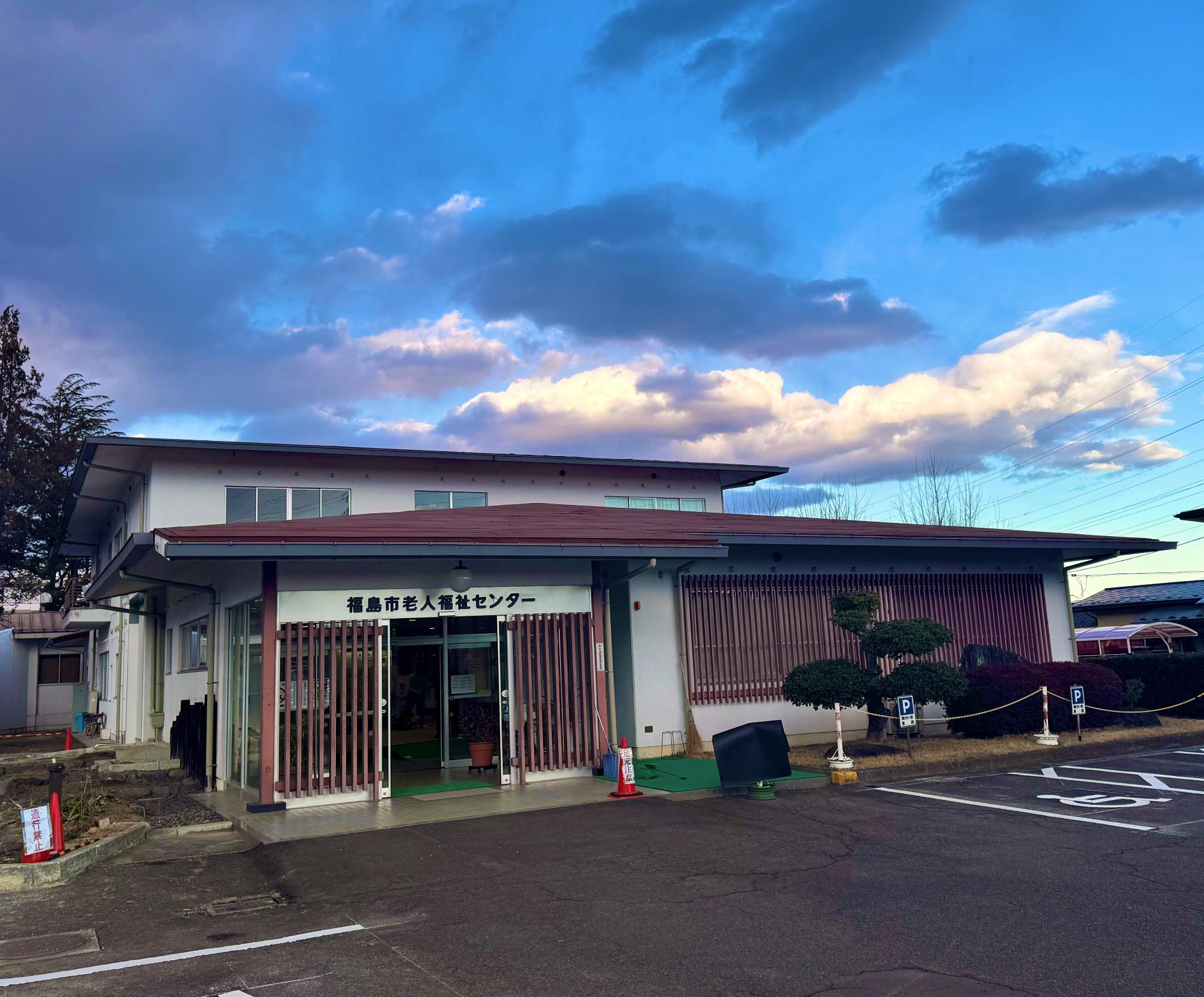 入り口上に「福島市老人福祉センター」と書かれた2階建てで白壁の建物外観の写真
