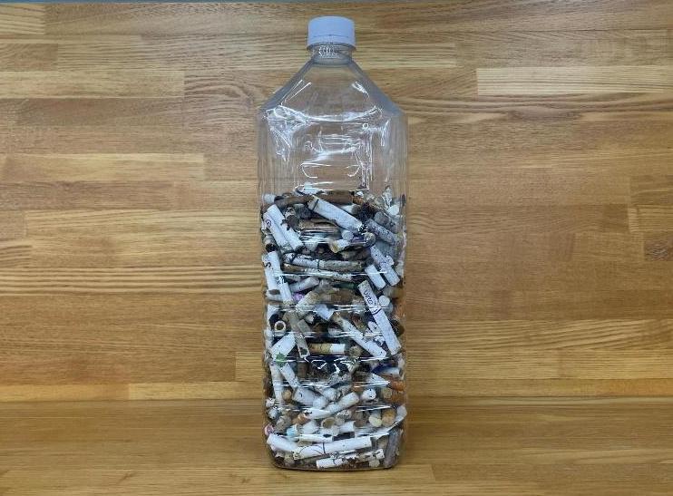 30分間のゴミ拾い活動で拾ったたばこの吸い殻を入れた2リットルペットボトル
