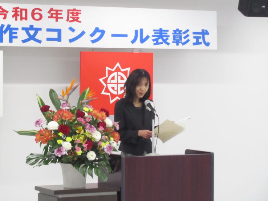 スーツを着た福島YUKIさんが壇上で発表する様子の写真