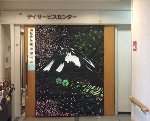 ピンクの花や木々の葉、田畑などが描かれている福島市中央デイサービスセンター入口付近の写真