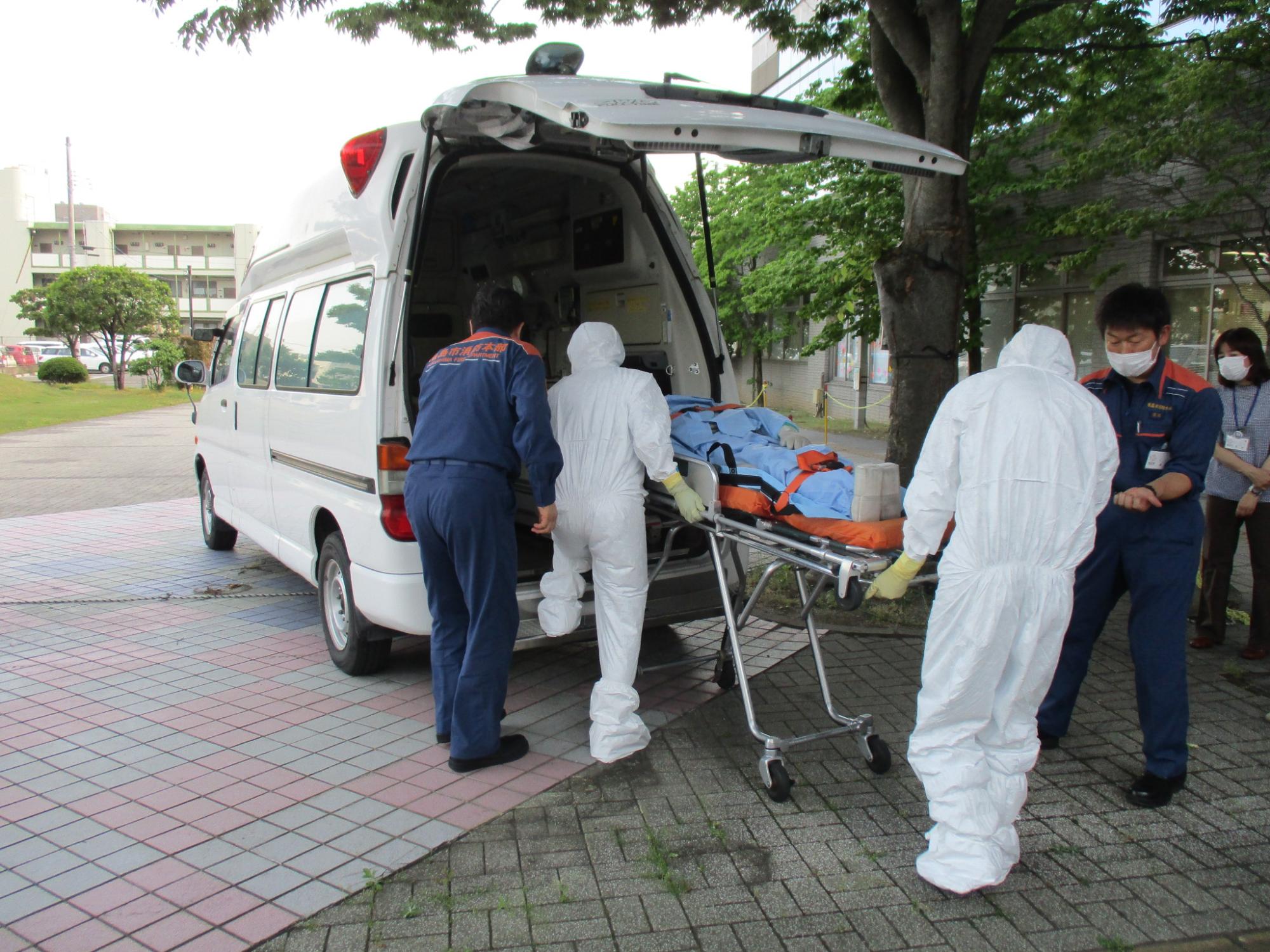 患者を保健所移送車に乗せている様子