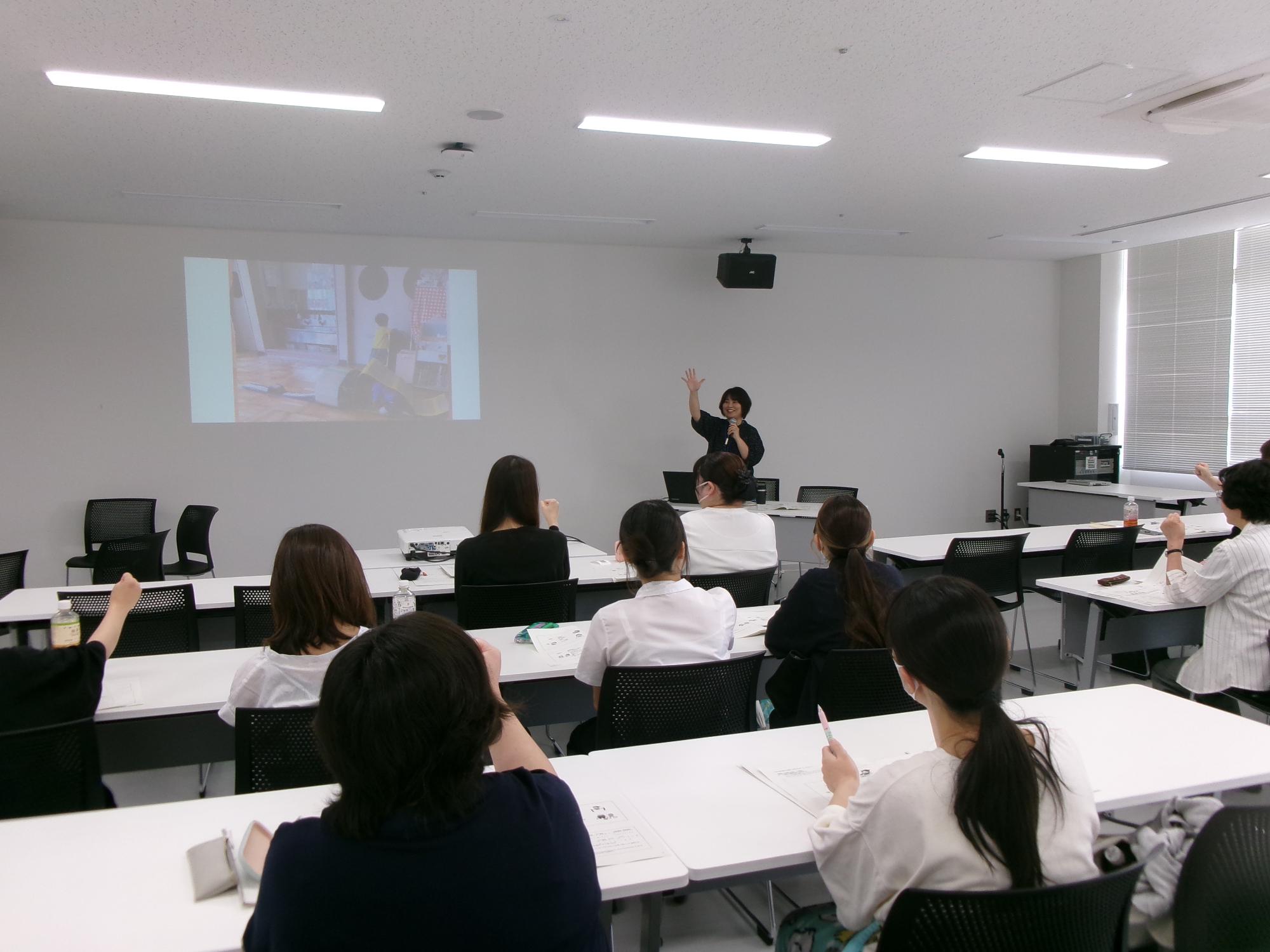 「こどもの発達と遊び」の講義の中で、じゃんけん遊びをする講師と受講者の写真