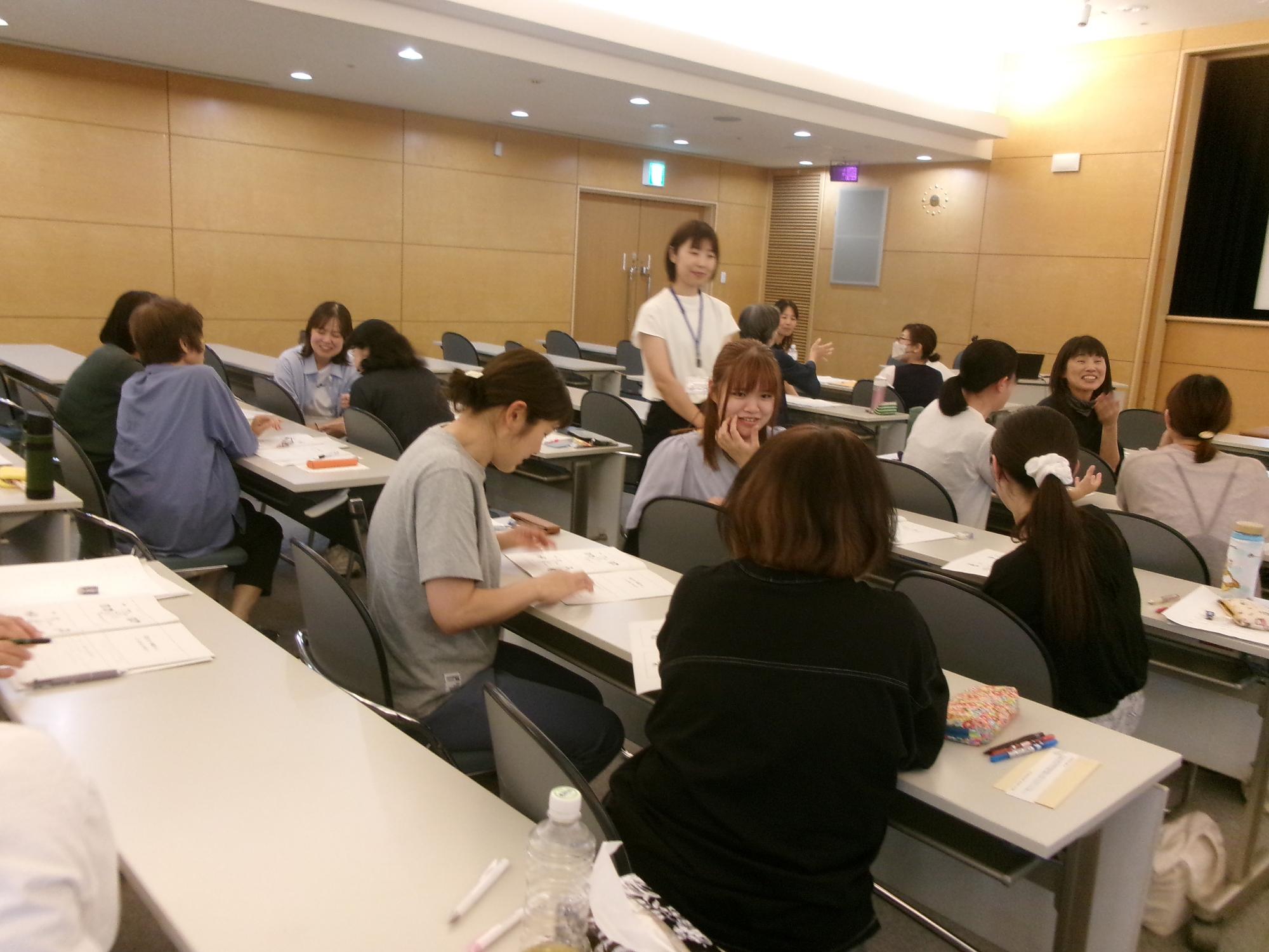 「こどもの発達と遊び」の講義の中で受講者のグループワークを見守る講師の写真