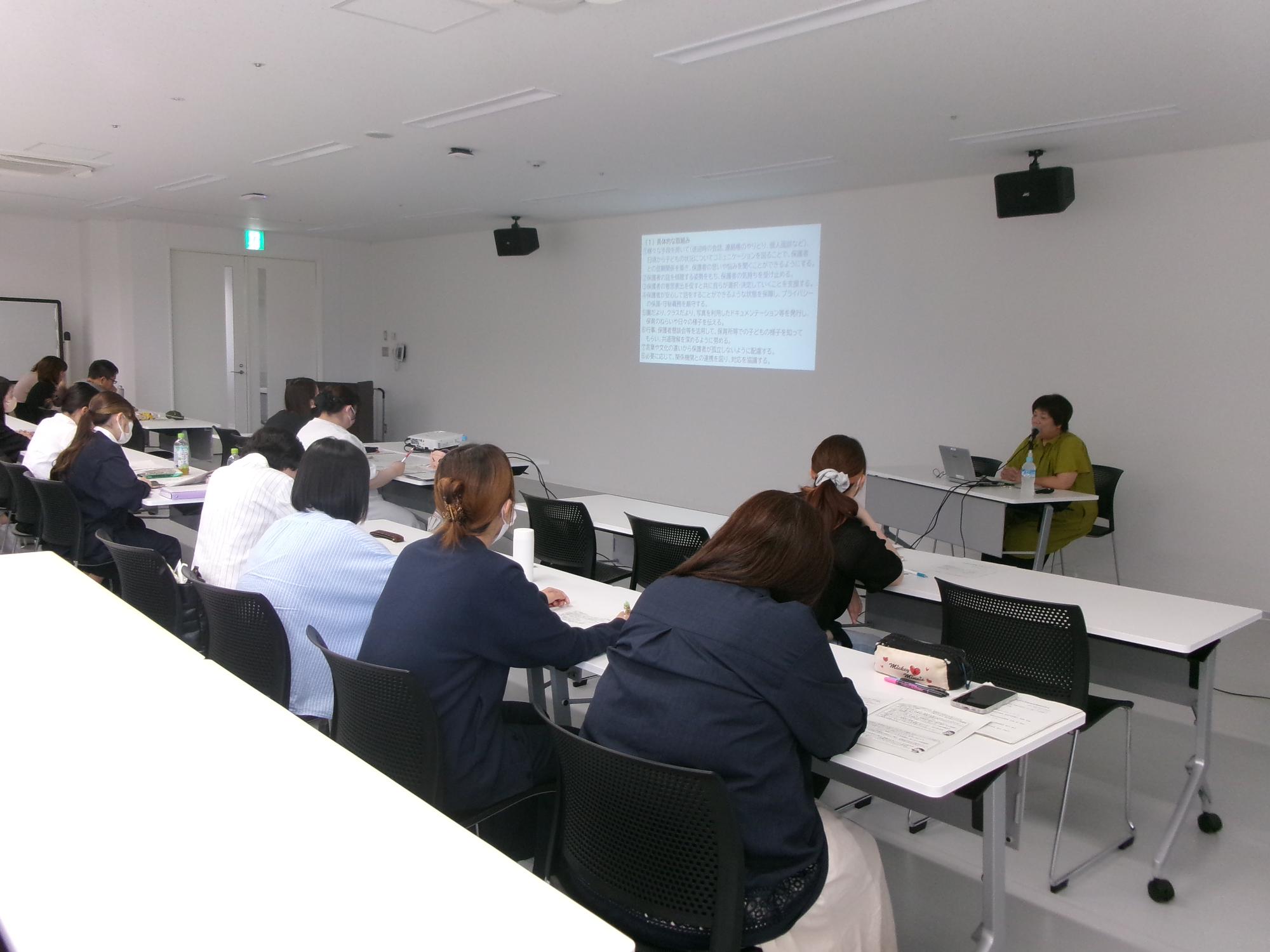 「保護者支援」の講義をする講師と受講者の写真