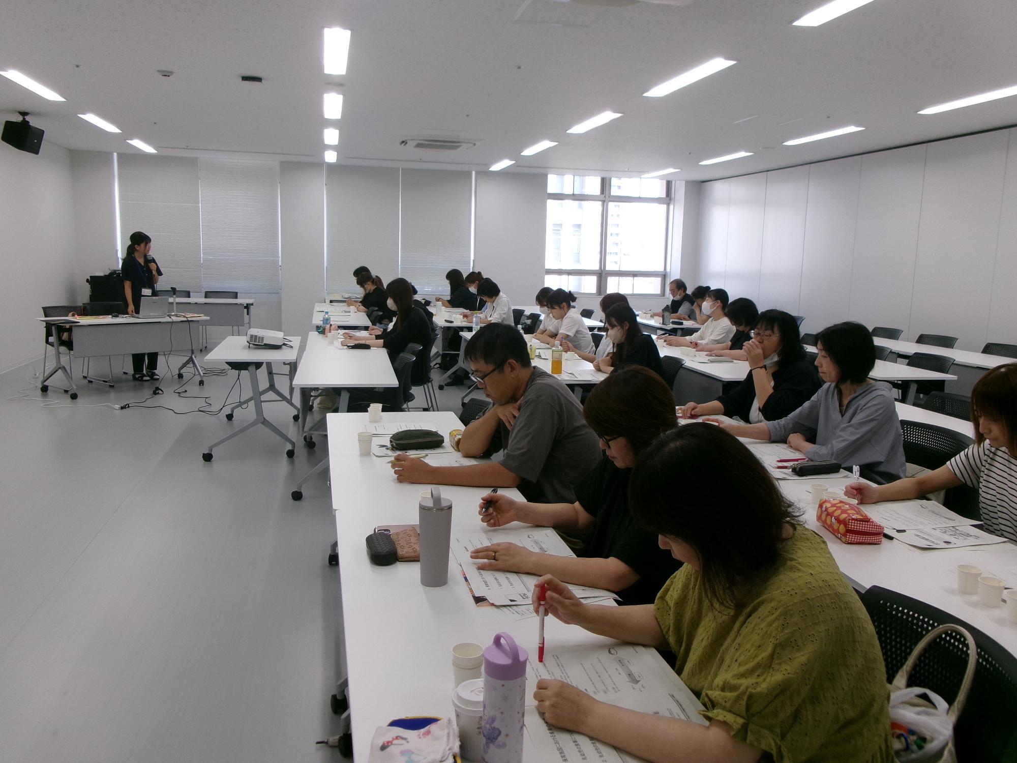 「保育施設における食育の実践と食物アレルギーについて」の講義をする講師と受講者の写真