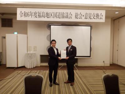 令和6年度福島地区国道協議会 総会・意見交換会と書かれたボードの前で、木村康博道路部長と福島市長が要望書を持ち記念撮影をしている写真