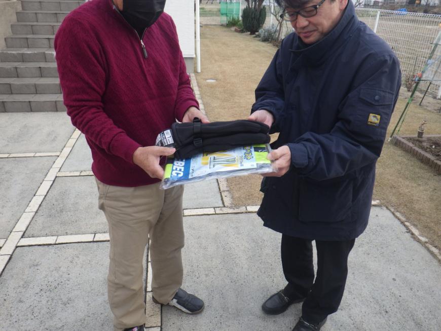 男性と市長が支給された商品を持っている様子の写真
