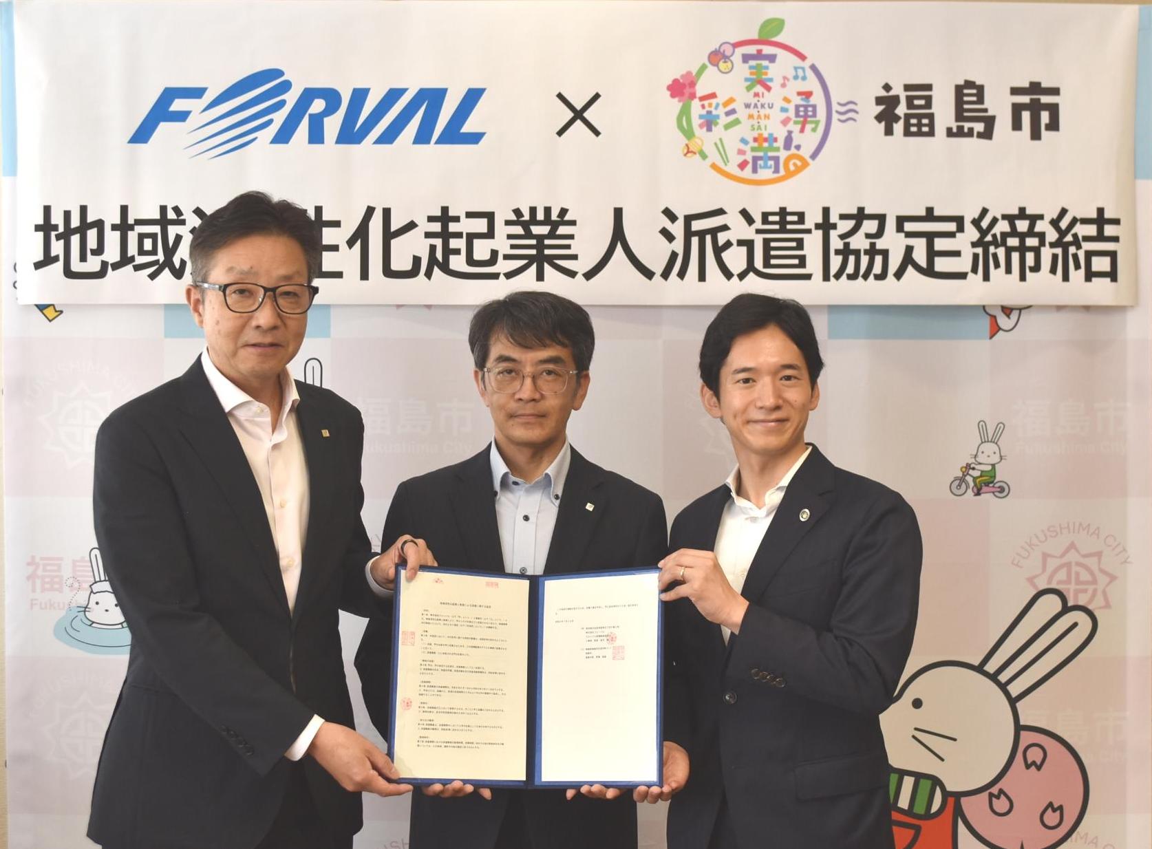 福島市のバックパネルの前で協定書を開いた状態で中央の男性が持ち、市長と関係者の男性が一緒に持って並んでいる写真