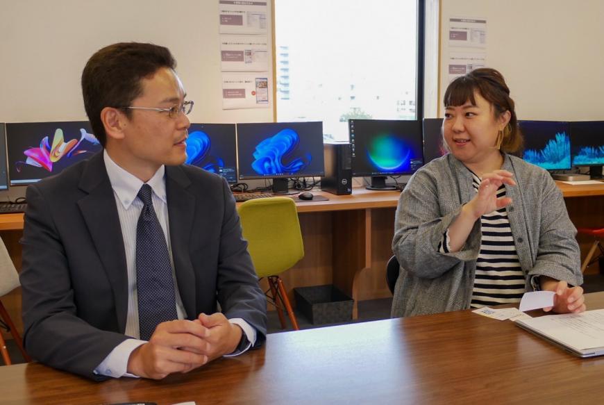 福島市デジタル推進課の秦さんとWebデザイナーの山下さんが隣り合って座り話をしている写真