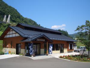 山に囲まれ入り口に看板が設置された茂庭ふるさと館の写真
