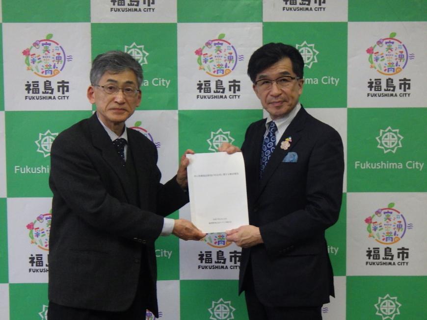 福島市のバックボードの前で男性2名で報告書を持っている写真