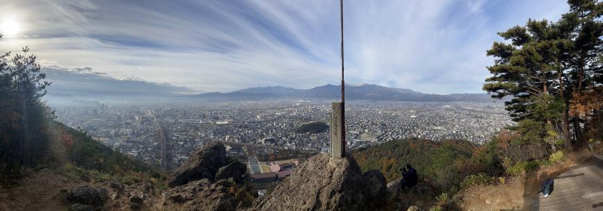 市街地と後方の山々が見渡せる烏ヶ崎展望デッキからの眺望のパノラマ写真