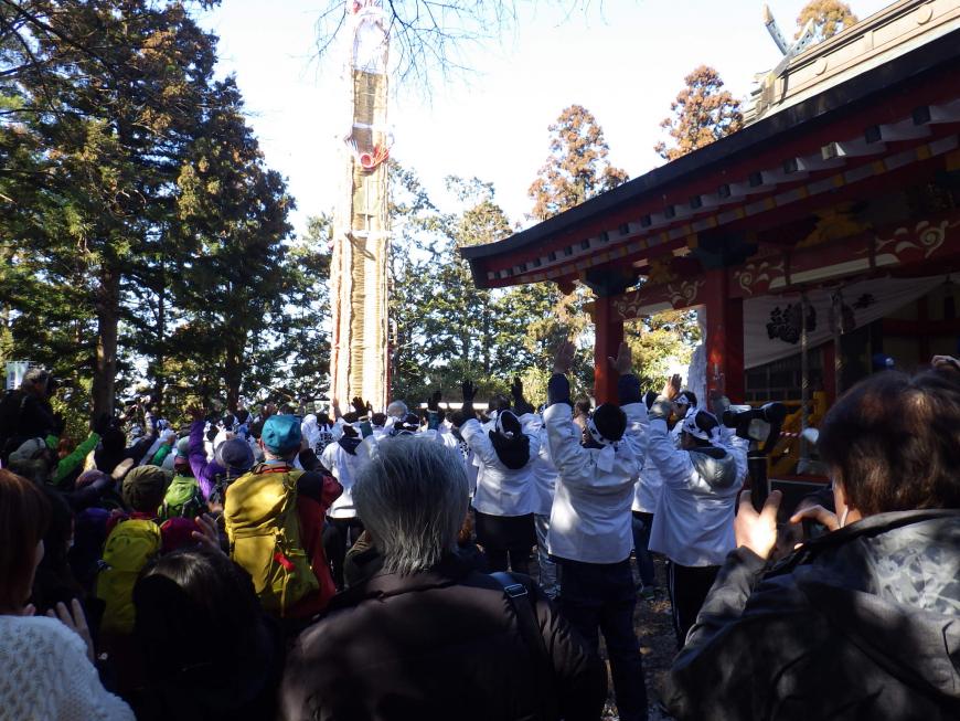 担いできた大わらじを神社に奉納が完了し、関係者が両手を万歳のようにあげている様子の写真