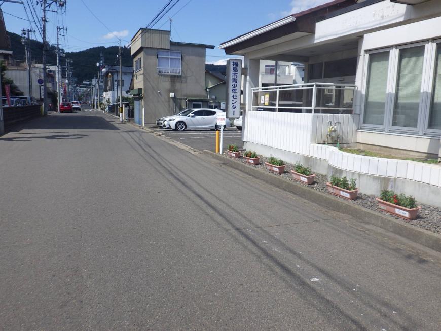 建物の壁に沿って等間隔に設置されたプランターの写真