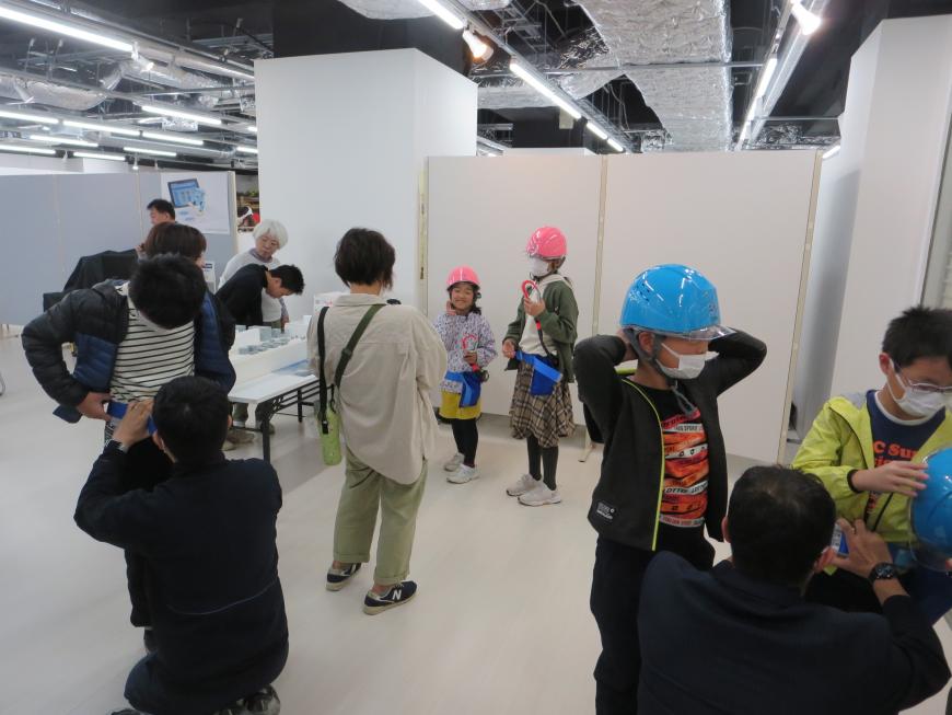 ピンクやブルーのヘルメットを頭に被っている親子の参加者の写真