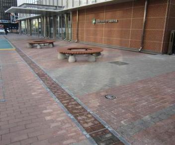 円形のベンチが2台設置された大学の入り口付近の写真