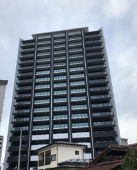 各階にベランダが設置されている高層マンションを正面から写した写真