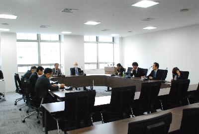 ロの字型に設置した机に委員が座り会議が行われている様子の写真