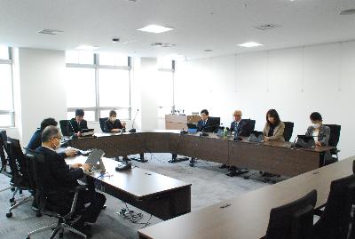 ロの字型に設置した机に委員が座り会議が行われている様子の写真