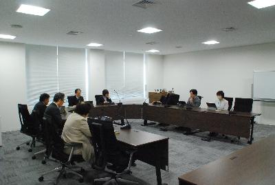 ロの字型に設置した机に委員が座り会議が行われている様子の写真
