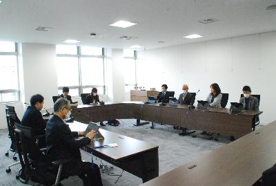 ロの字型に設置した机に委員が座り会議が行われている様子の写真